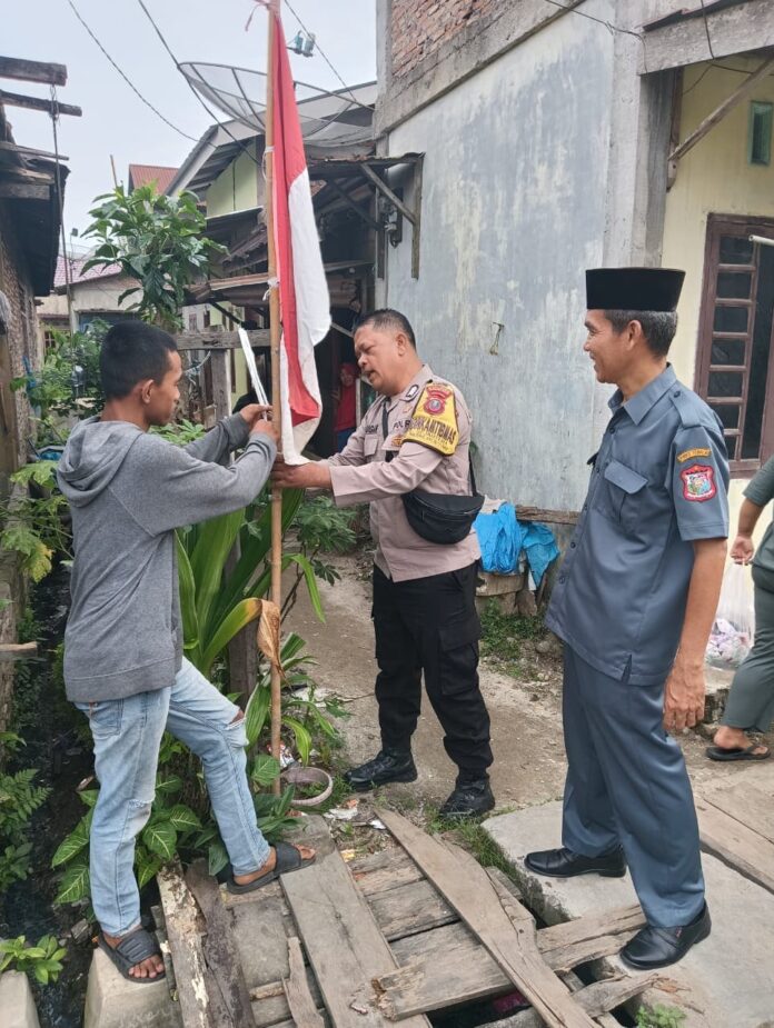 Sambut HUT ke-81 RI, Bhabinkamtibmas Polsek Tanjung Balai Utara Ajak Warga Kibarkan Merah Putih