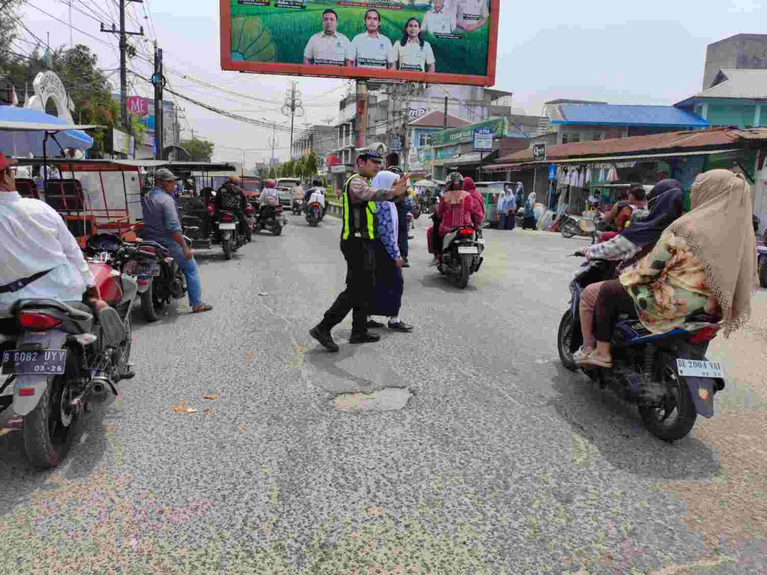 Sat Lantas Polres Tanjung Balai Amankan Arus Pulang Sekolah, Siswa Diseberangkan